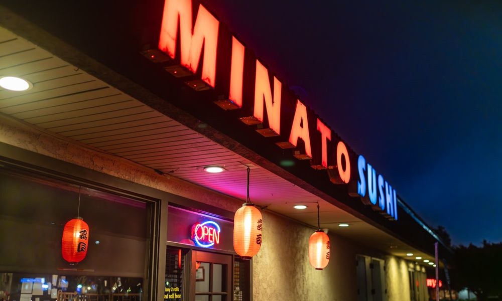 Minato Sushi at night, the neon sign, red lanterns, and the OPEN sign lit